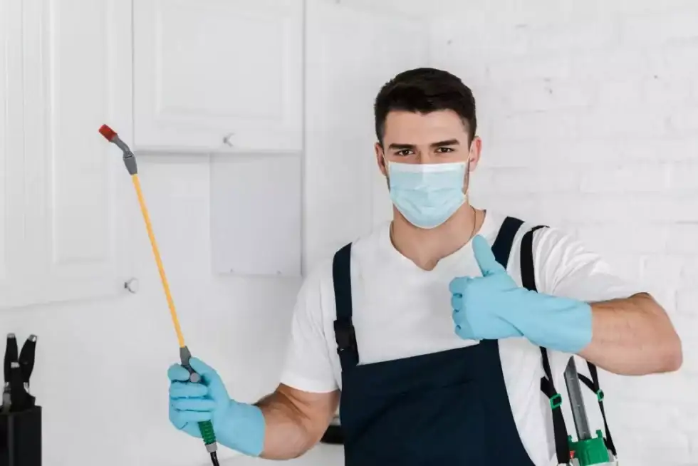 exterminator-in-uniform-holding-toxic-spray-and-showing-thumb-up pest control services in dhaka